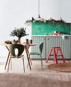 Round table with chairs and green tiles above base cabinet in kitchen decorated for Christmas