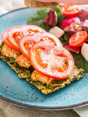 Homemade gluten free seed cracker with vegan pesto, tofu and tomatoes, served with side salad