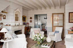 White slip covers on armchairs with beamed ceiling in 18th century conversion