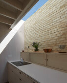 Kitchen counter, brick wall and skylight in modern kitchen