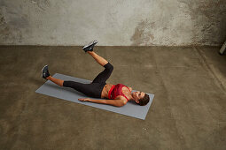 A young woman lying on her back with one leg bent up