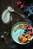 A vegan blue smoothie bowl with spirulina, fruits and nuts