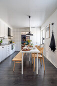 Long table with chairs and bench in white kitchen