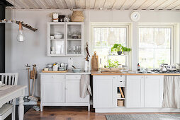 Simple dresser and glass-fronted cabinet in shades of grey with rustic accessories