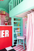 Counter and seating area below loft level in play house in American fifties style