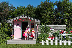 Play house in American fifties style and children playing in garden