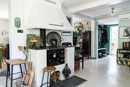 Traditional, wood-fired stove in open-plan, vintage-style interior