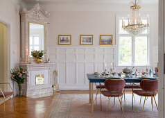 Velvet chairs around festively set dining table in glamorous dining room