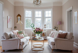 Two sofas facing one another in elegant living room with bay window