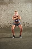 A woman performing a squat with her knees turned out