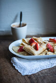 Vegan crepes with strawberries, chocolate sauce and roasted almonds