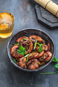 Black pepper prawns in a bowl with beer