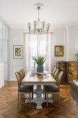 Medallion chairs around dining table in period building with herringbone parquet floor