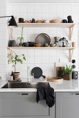 Wooden shelves above sink unit with grey base cabinets