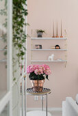 Hortensie auf Metalltisch im Wohnzimmer mit rosa Wand
