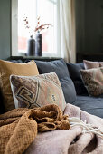 Zierkissen und Decken auf gemütlichem Übereck-Sofa
