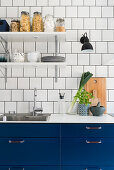 Kitchen with blue cupboards and white tiled wall