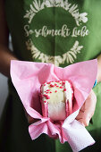 Frau hält grosses Macaron mit Pralines Roses