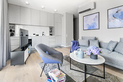 Open-plan interior in shades of grey with purple accents