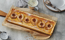 Pear tart on a wooden board with baking paper