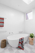 Freestanding bathtub on checkerboard floor in the bathroom in white