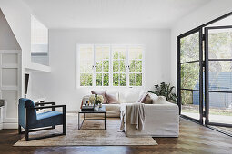 Living room with white sofa and window front to the garden