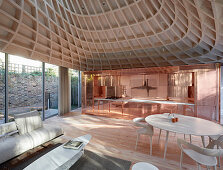 Offener Wohnraum mit Lounge und Küche in Kupfer in modernem Anbau mit Verglasung und trichterförmigem Dach