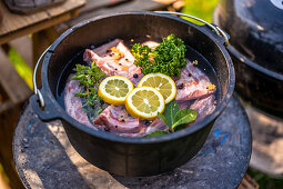 Spare ribs with herbs, lemons and spices being cooked in a Dutch oven