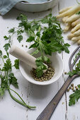 Green pepper in a mortar next to chervil and asparagus