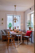 Wooden bench in Scandinavian-style dining area below oil-lamp-style pendant lamp