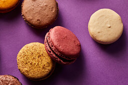 Assortment of colorful macarons on purple background