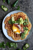 Waffels with bacon, cheese, chili, poached eggs. avocado and koriander