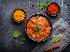 Chicken tikka masala with spicy curry meat served in rustic ceramic bowl, popular Indian dish