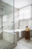 Dusche und Badewanne im modernen Bad in Grau