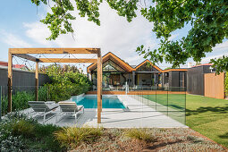 Swimming pool with glass partitions in the garden of an architect's house