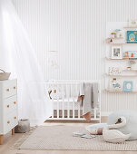 Baby room in bright colors with cot, chest of drawers and wall shelf