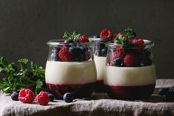 Homemade classic dessert Panna cotta with raspberry and blueberry berries and jelly in jars
