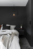 Bedroom with black walls and light bulb pendant lamp