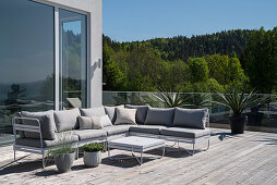 Outdoor couch on wooden desk of spacious roof terrace