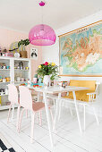 Pink pendant lamp providing a splash of colour above white dining table