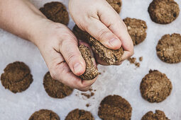 Breaking freshly baked chocolate cookies into halves