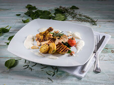 Chicken breast with grilled potatoes, cherry tomatoes, rosemary, spinach and almonds