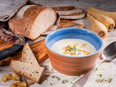 Parsnip cream soup with garlic chips, cress and rye bread