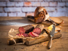 Beef salami in natural gut casing, rye bread, pepper, and butter