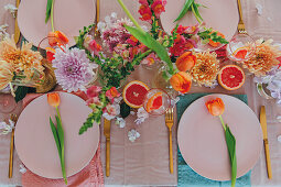 Gedeckter Tisch mit Blumen und rosa Grapefruit zum Muttertag
