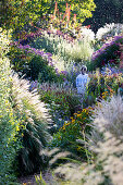 Woman walks through natural summer garden with lush perennials
