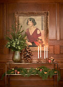Festively decorated console table below painting on wooden wall panelling