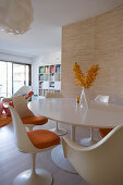 Round, white, classic Tulip table and matching chairs in dining area