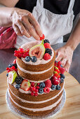 Wedding cake with almond layers, raspberry buttercream, raspberry filling, and fresh fruit
