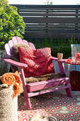 Pink deck chair with fur blanket and cushion on comfortable terrace